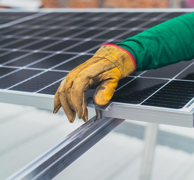 Gloved hand on solar panel