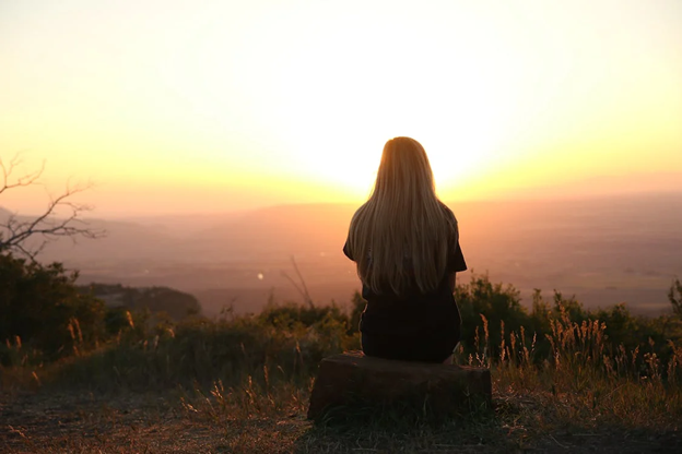 Woman looking at a sunset horizon
