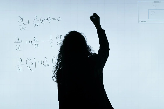 Woman writing a calculation on a whiteboard